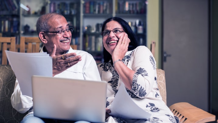 An elderly couple sitting on a couch 