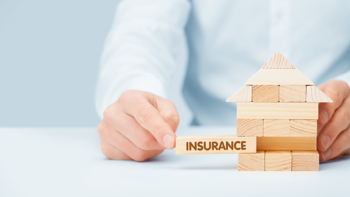 wooden model of the house with text insurance