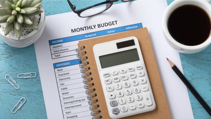 calculating monthly budget with a white calculator