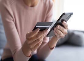 Credit Cards on UPI: FAQs - Women holding credit card and cellphone - Metra Trust