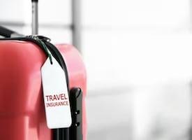 Credit cards with CFAR travel insurance - Suitcase with travel insurance tag - Metra Trust